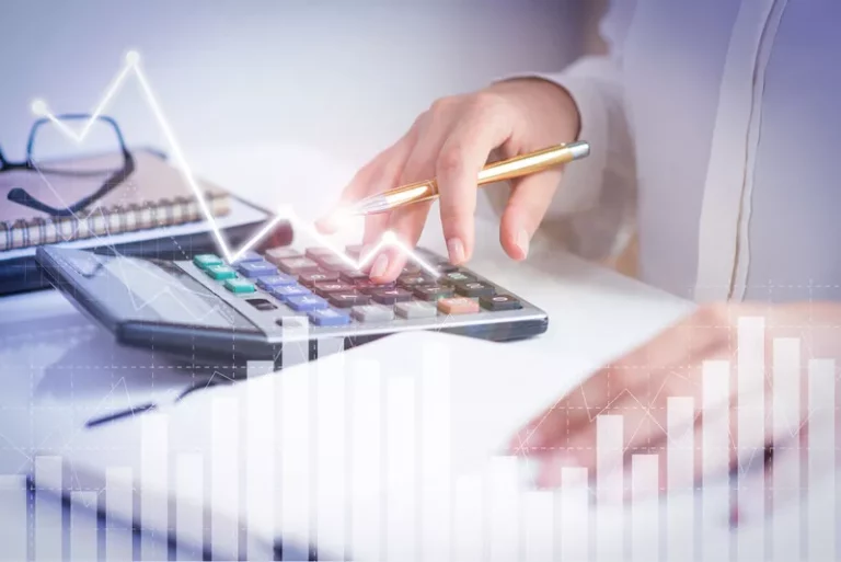 Một người đang sử dụng máy tính và có những biểu đồ tăng trưởng ảo ở phía trước
