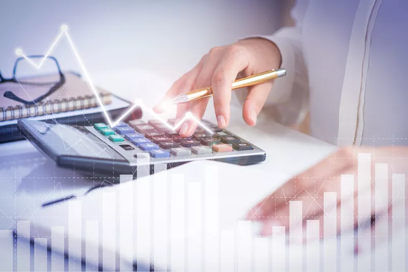 Một người đang sử dụng máy tính và có những biểu đồ tăng trưởng ảo ở phía trước