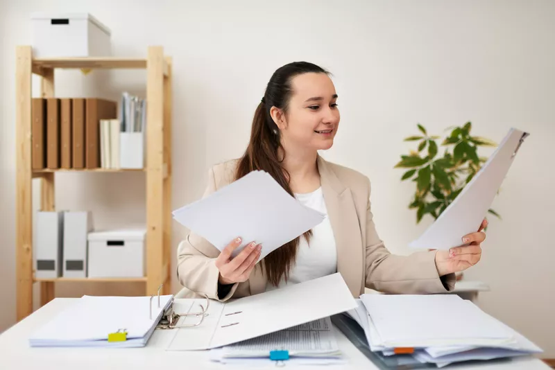 Người phụ nữ kế toán đang xem xét hồ sơ tài chính, quy trình quyết toán thuế giải thể doanh nghiệp